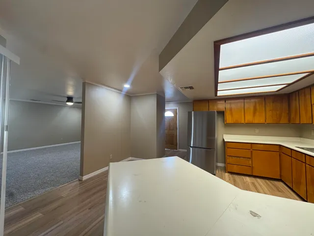 an empty room with ceiling fan and windows