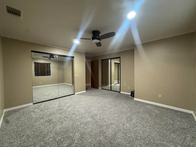 a view of an empty room with a ceiling fan