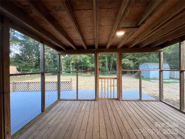 a view of empty room with wooden floor and balcony