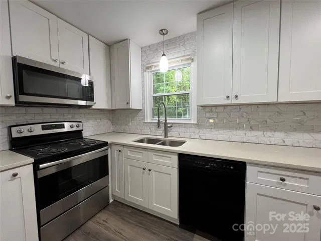 a kitchen with granite countertop cabinets stainless steel appliances a sink and window