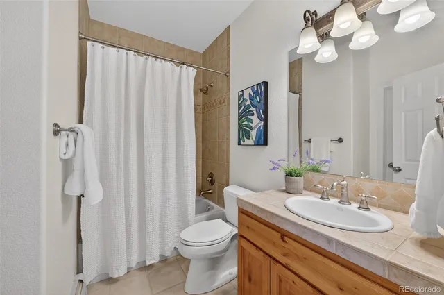 a bathroom with a granite countertop sink a toilet and a mirror