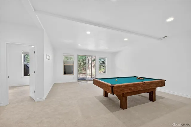 a room with pool table and windows