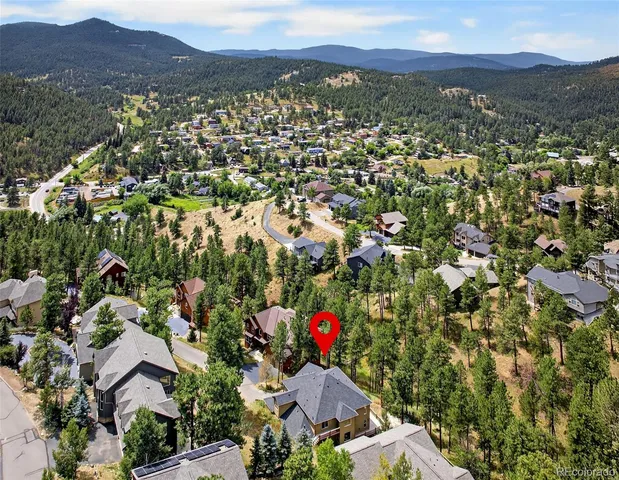 an aerial view of residential house with an outdoor space and mountain view in back