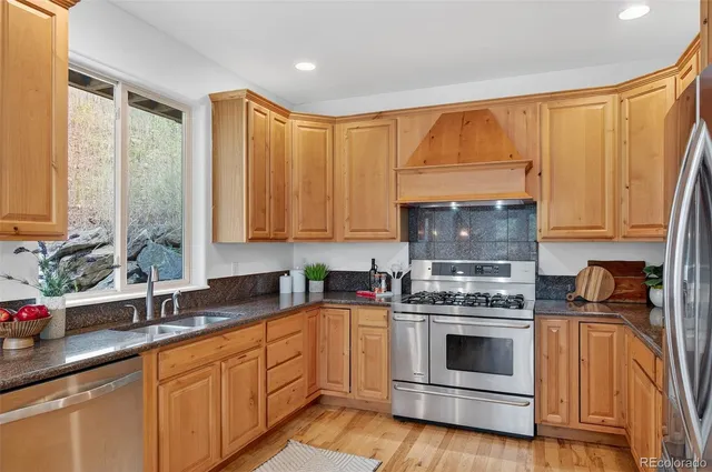 a kitchen with stainless steel appliances a stove a sink a microwave and cabinets