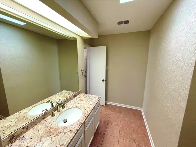 a bathroom with a granite countertop sink and a mirror