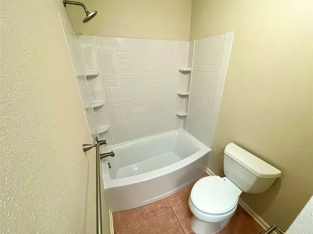 a white toilet sitting next to a bath tub