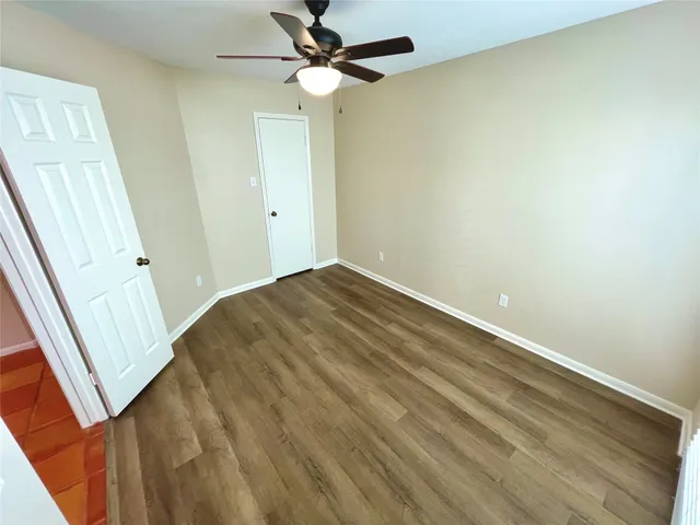 an empty room with a mirror and a fan