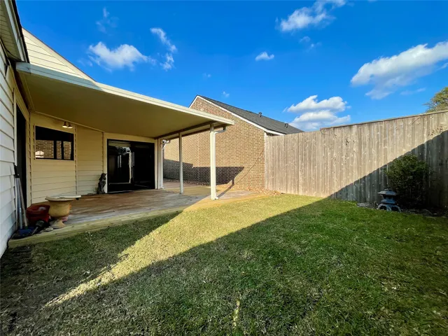 a view of a backyard with table and chairs with wooden fence