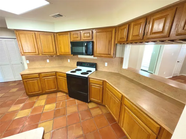 a kitchen with stainless steel appliances granite countertop a sink wooden cabinets and a stove top oven