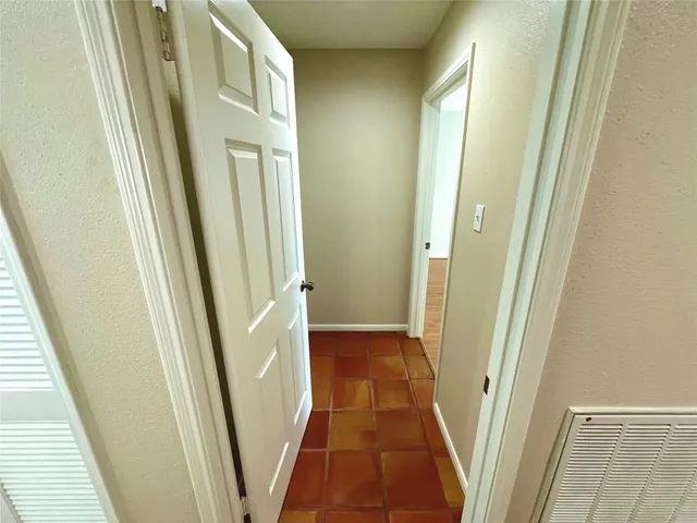 a view of a hallway with wooden floor and stairs