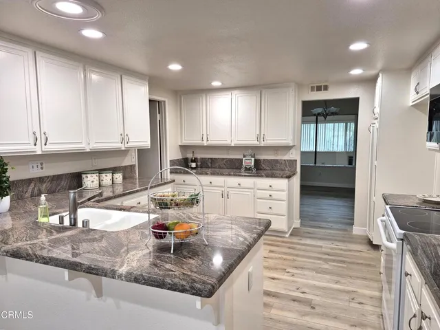 a kitchen with stainless steel appliances granite countertop a sink stove and cabinets