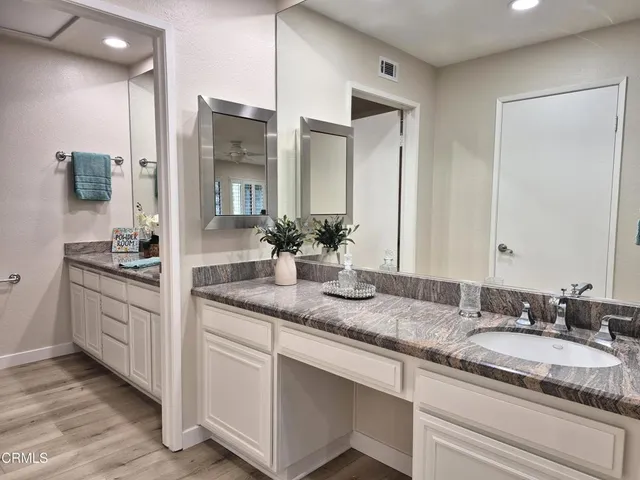a bathroom with a granite countertop double sink and a mirror
