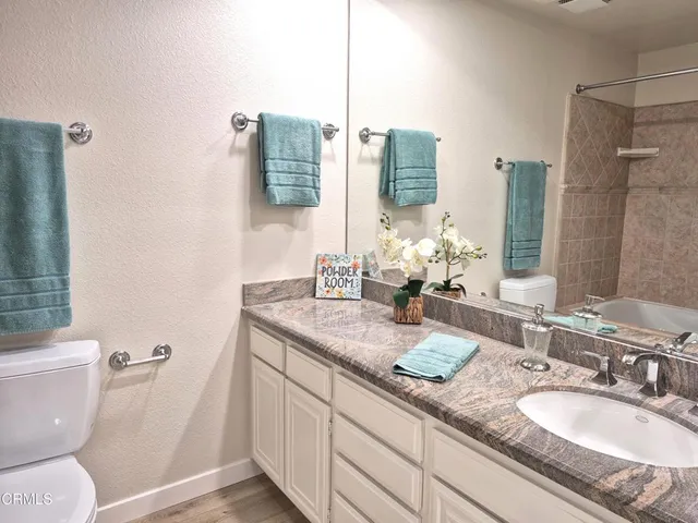 a bathroom with double vanity sink toilet and shower