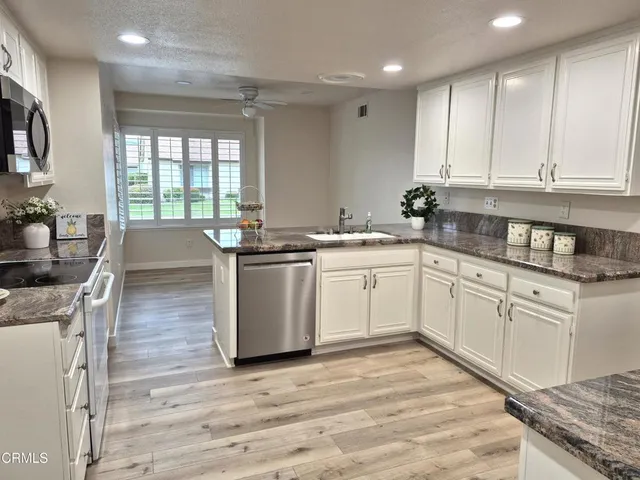 a kitchen with stainless steel appliances granite countertop a sink stove and cabinets