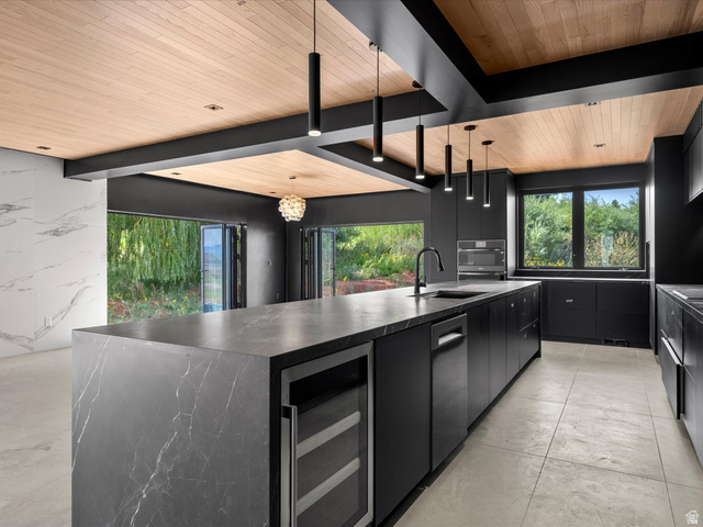2610 Foxridge Road Garden City, UT 84028 - Photo 31 of 71 Gourmet kitchen featuring a waterfall island with integrated wine refrigeration, ceiling-mounted pendant lighting, a built-in oven, and a wood-paneled ceiling