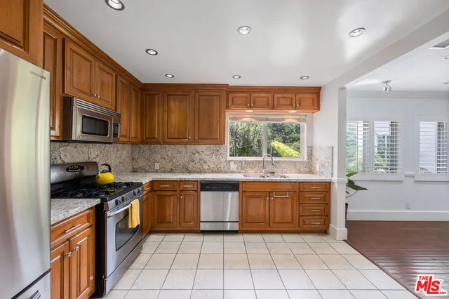 a kitchen with stainless steel appliances granite countertop a stove top oven a sink a counter top space and cabinets