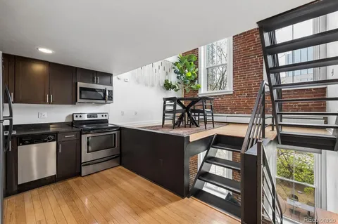 a kitchen with granite countertop a stove a sink and a microwave