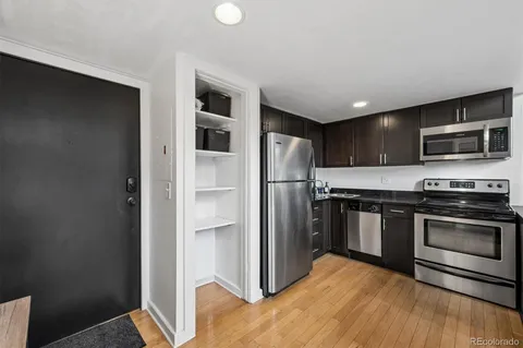 a kitchen with stainless steel appliances granite countertop a refrigerator and a stove top oven