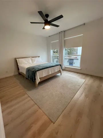 a spacious bedroom with a bed and a large window