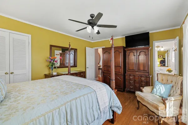a bedroom with a bed a couch and a chandelier