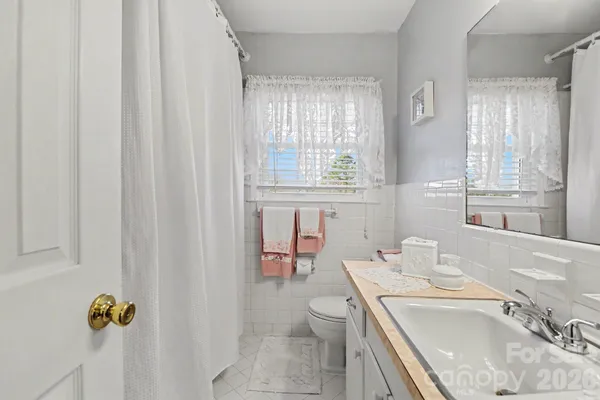 a bathroom with a sink toilet and window