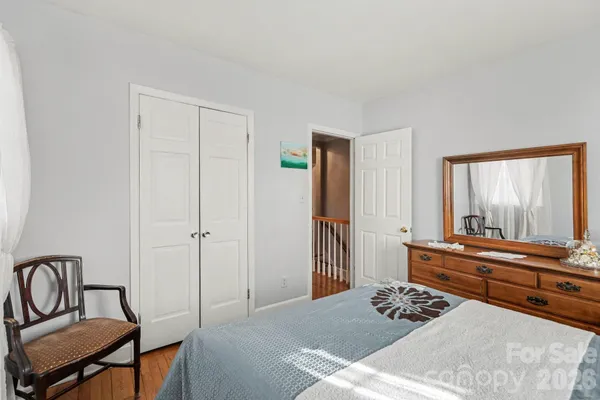 a bedroom with a bed and a dresser next to a window