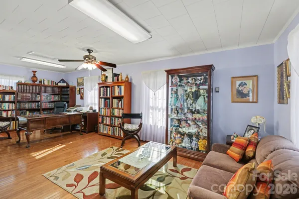 a living room with furniture a rug and a bookshelf