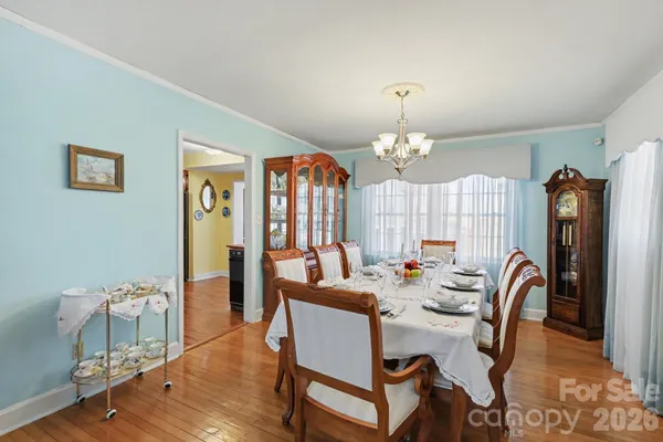 a dining room with furniture a chandelier and wooden floor