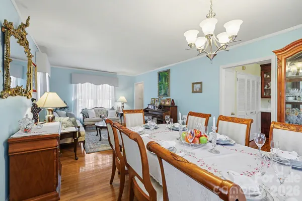 a view of a dining room with furniture a chandelier and wooden floor
