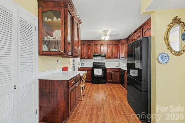 a kitchen view with stainless steel appliances granite countertop a refrigerator a stove top oven a sink and dishwasher