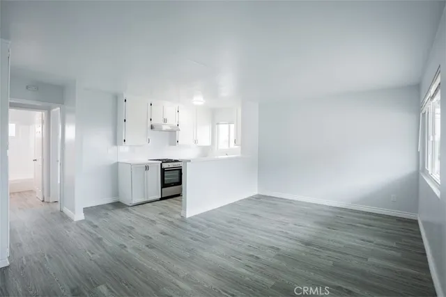 a kitchen with stainless steel appliances granite countertop a stove a sink and white cabinets
