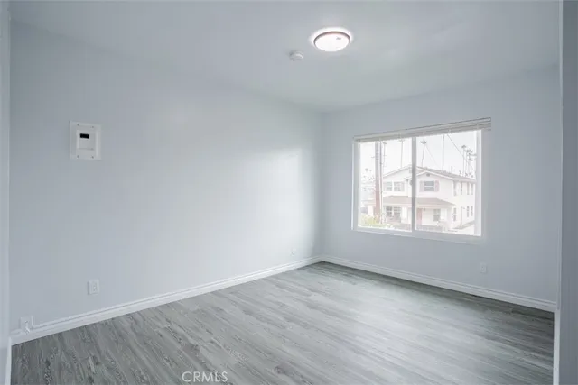 a view of an empty room with wooden floor and closet