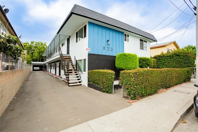 a view of a house with a yard and potted plants