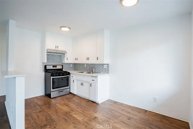 a kitchen with granite countertop a stove top oven and sink