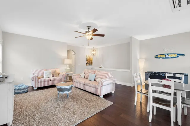 a living room with furniture a wooden floor and a chandelier