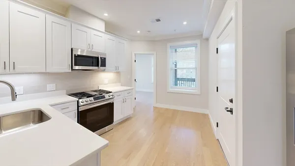 a kitchen with stainless steel appliances granite countertop a stove a sink and a microwave