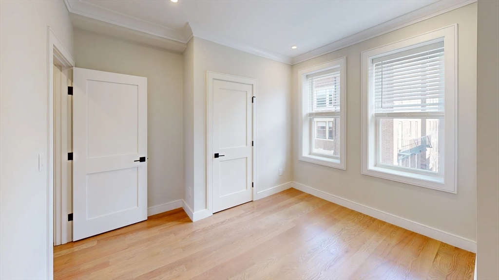 161 Allston Street, Unit 6 Boston, MA 02134 - Photo 4 of 6 a view of an empty room with wooden floor and a window