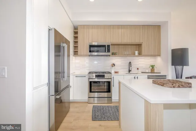 a kitchen with stainless steel appliances a stove sink microwave and cabinets