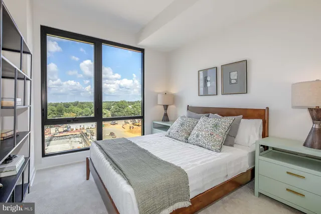 a large bed sitting in a bedroom next to a window