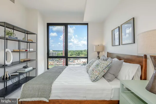 a bedroom with a bed a table and painting on the wall