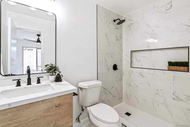 a bathroom with a sink a toilet and shower