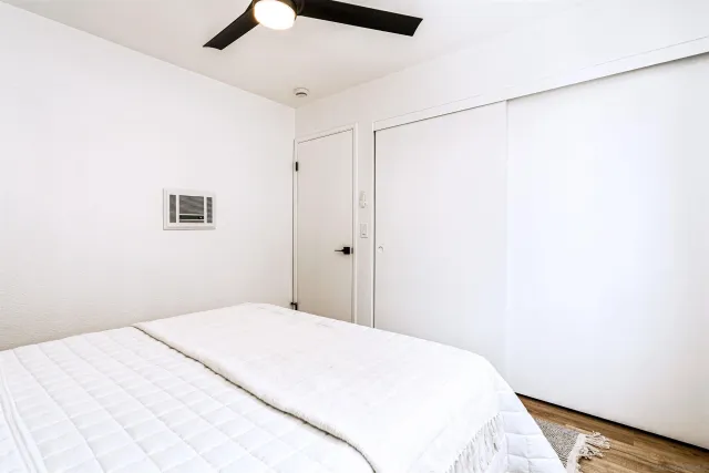 a bedroom with a bed and a chandelier fan