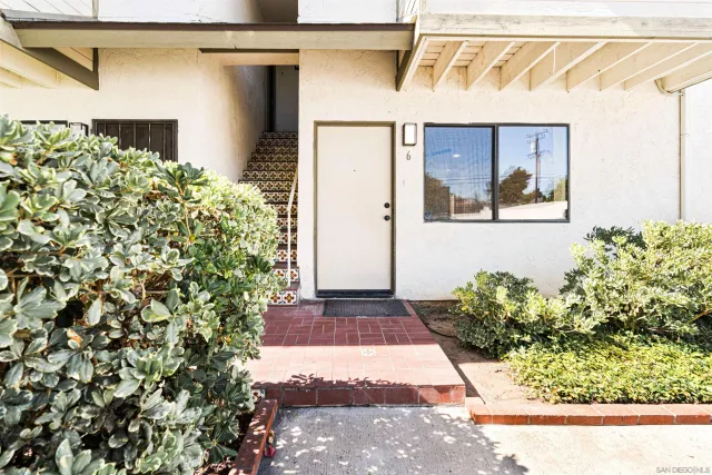 a front view of a house with a yard and a potted plant