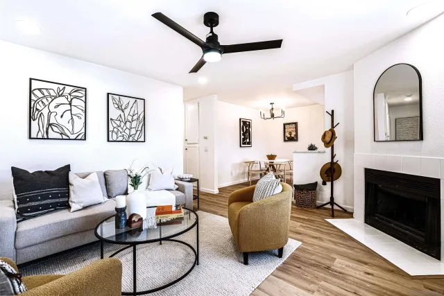 a living room with furniture a ceiling fan and a fireplace