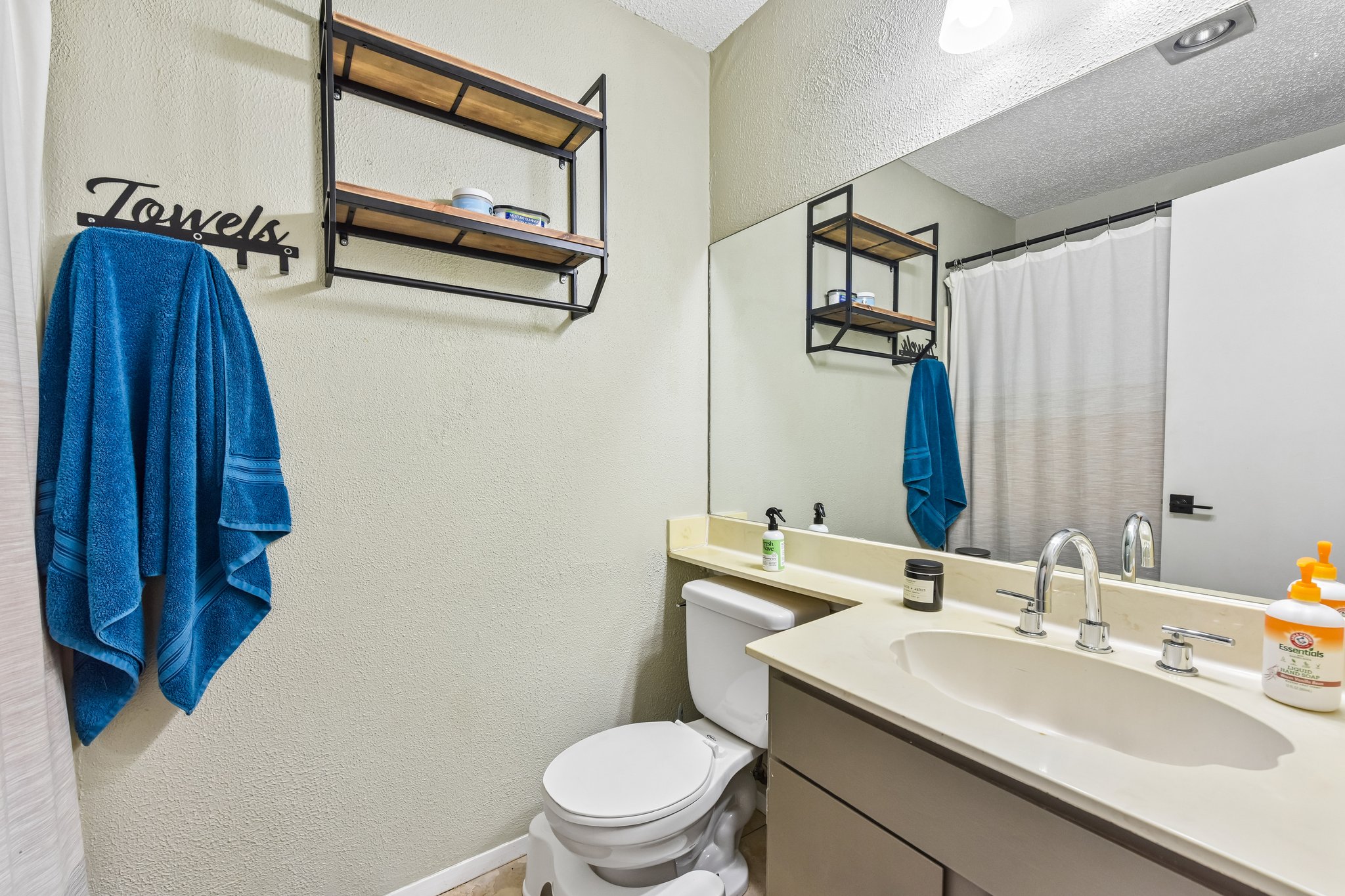 9610 Covey Ridge Lane Austin, TX 78758 - Photo 14 of 22 Bathroom featuring a full vanity with an integrated sink, a large wall-mounted mirror, a toilet, and a built-in shower/tub combination with a curtain rod