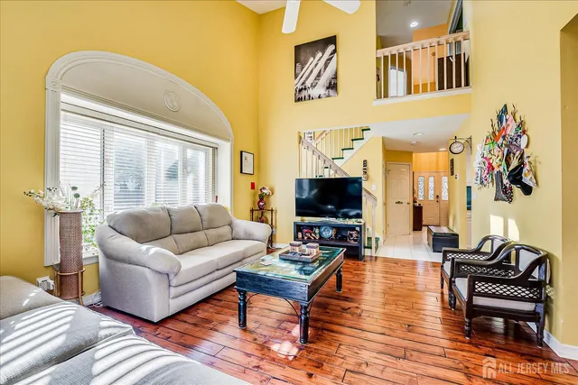 a kitchen with stainless steel appliances granite countertop a stove top oven a sink dishwasher and white cabinets with wooden floor