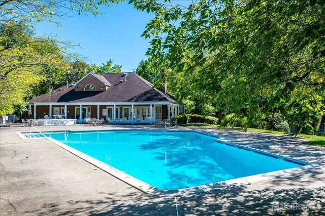 an aerial view of a house with a yard and large trees