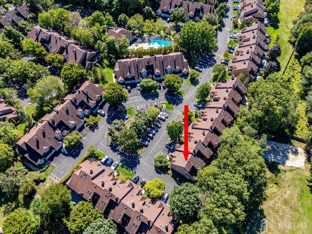 an aerial view of a residential houses and car parked on street side