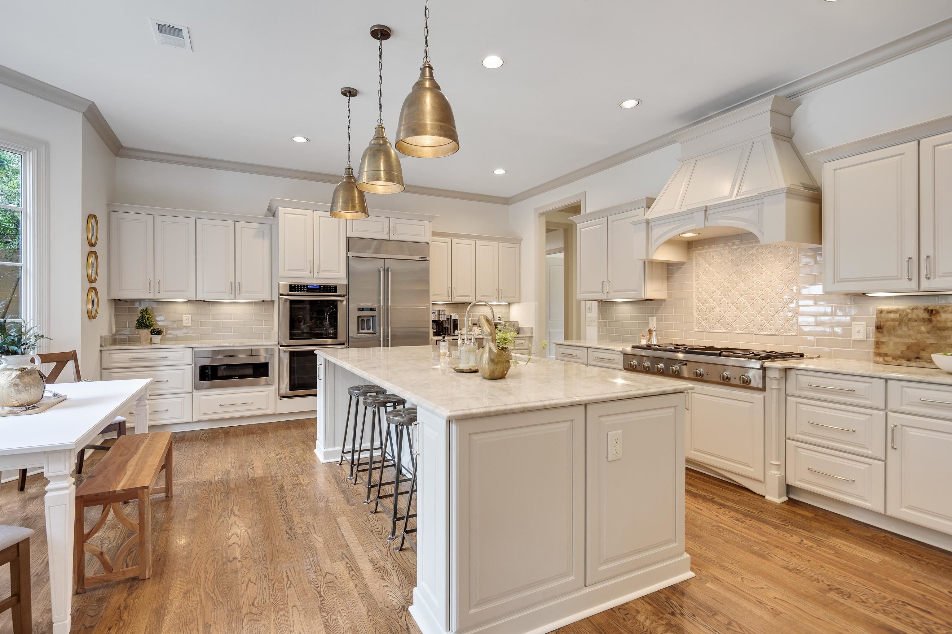 101 North Grove Park Road Memphis, TN 38117 - Photo 12 of 40 Kitchen with crown molding, light wood-style floors, stainless steel appliances, and white cabinetry