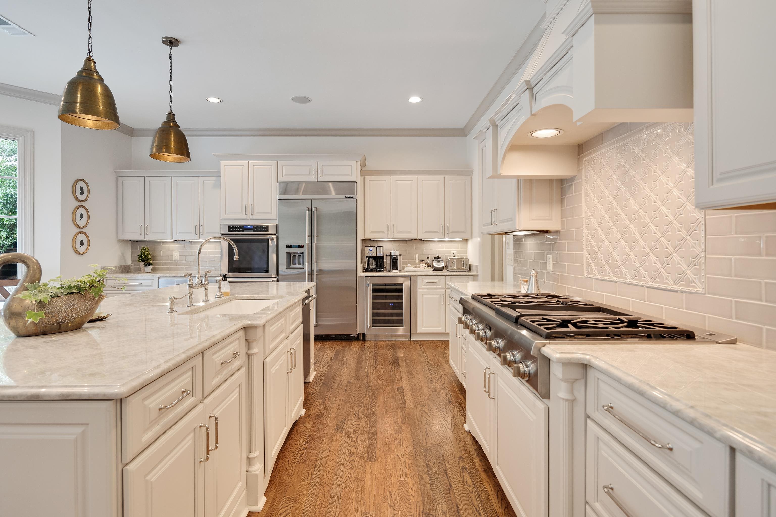 101 North Grove Park Road Memphis, TN 38117 - Photo 13 of 40 Kitchen with crown molding, wine cooler, stainless steel appliances, light wood-type flooring, and white cabinetry